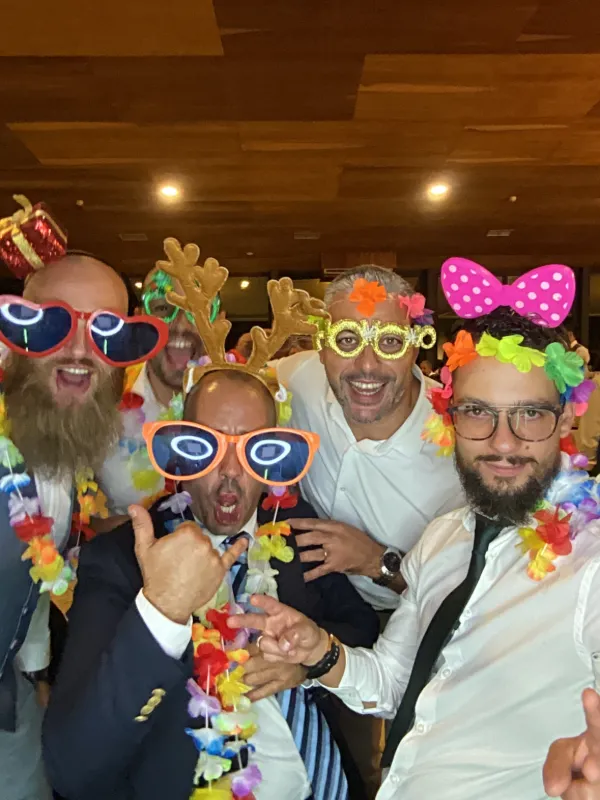 Convidados com óculos gigantes e laços de festa a posar para o Photobooth.